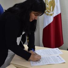 Egresada firmando el acta de titulación