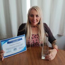 Angélica Villegas, estudiante de UDGVirtual con el premio y un reconocmiento