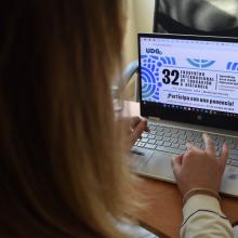 Mujer frente a una laptop consultando la convocatoria de ponencias del Encuentro Internacional de Educación a Distancia 