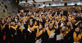 Egresados lanzando birrete, durante acto académico