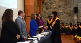 Egresada recibiendo su reconocimiento de manos de la rectora del Sistema de Universidad Virtual