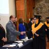 Egresada de la licenciatura en Gestión Cultural recibiendo la documentación de manos del presídium